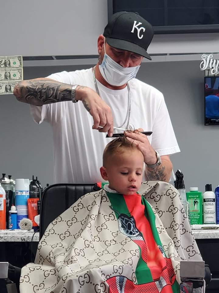Stylz cutting the hair of a preschool-aged child.