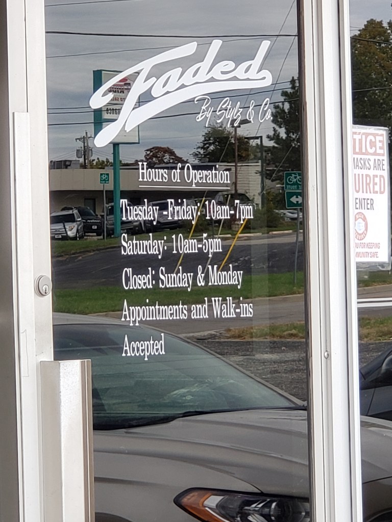 The front door of the shop listing the hours of operation.
