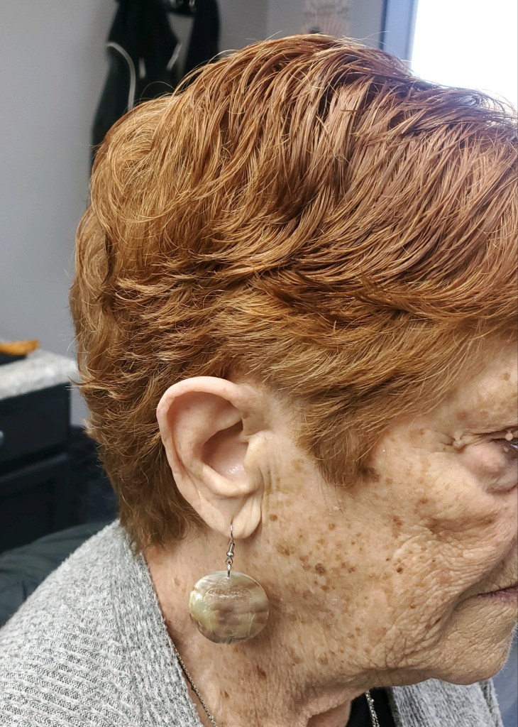 An older woman with freshly cut hair.